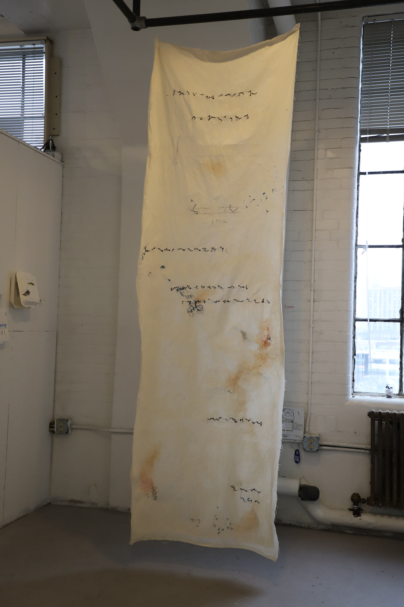 Long vertical textile scroll, Notes, featuring repetitive linear columns of dark hand stitching and delicate watercolor washes on off-white cotton fabric.